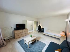 een woonkamer met een bed en een televisie bij La Suite Victor Hugo - Centre-ville - Taittinger in Reims