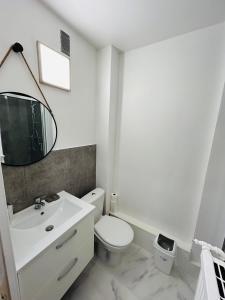 een witte badkamer met een toilet en een wastafel bij La Suite Victor Hugo - Centre-ville - Taittinger in Reims