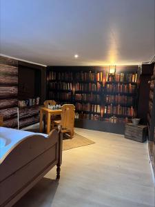 biblioteka z łóżkiem, stołem i książkami w obiekcie Les Petites Bulles de Massier we Vienne