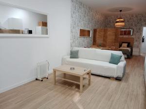 sala de estar con sofá blanco y mesa en estudio el Torcal, en Málaga