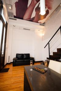 a living room with a couch and two glasses of wine at Loft Osteria by Sagardi in Buenos Aires