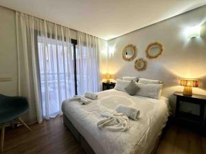 a bedroom with a large bed with towels on it at Appart de standing + piscine sur le toit in Marrakech +17 photos