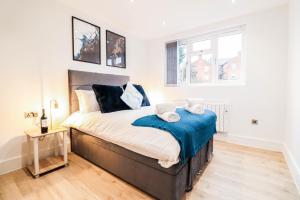 BuckinghamshireにあるModern 1-Bed Apartment in Buckinghamshire with Free WiFi, Parking & Gardenのベッドルーム1室(大型ベッド1台、青いシーツ付)