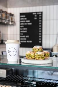 a plate of donuts and a cup of coffee on a counter at The Modernist Thessaloniki in Thessaloniki