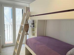 Un dormitorio con una litera con sábanas moradas en POAL-Dúplex de ensueño en Cadaqués en Cadaqués