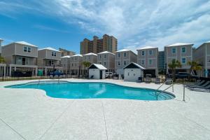 a large swimming pool with buildings in the background at Newly Built, Luxury Home w/ pool & beach access in Gulf Shores