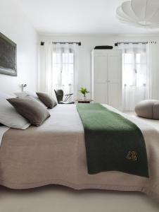 a bedroom with a large bed with a green blanket on it at Metafort in Méthamis