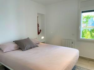 a large white bed in a room with a window at POAL-Dúplex de ensueño en Cadaqués in Cadaqués