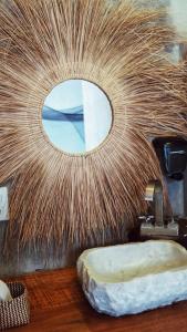 La salle de bains est pourvue d'un miroir circulaire et d'une pierre. dans l'établissement Casa Xadani, à Cerro Largo