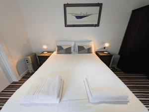 a bedroom with a large white bed with two lamps at Bay & Harbour Holiday Apartments & rooms only in Weston-super-Mare