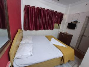 ムンバイにあるSai residencyの赤い窓が備わるドミトリールームの小さなベッド1台分です。