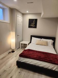 a bedroom with a large bed and a lamp at Stylish Retreat in North Oshawa in Oshawa
