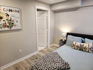 a bedroom with a bed with a leopard blanket on it at Stylish Retreat in North Oshawa in Oshawa