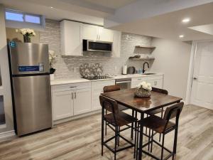 a kitchen with a table and a refrigerator at Stylish Retreat in North Oshawa in Oshawa