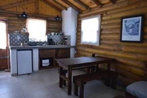 una cocina en una cabaña de madera con una mesa de madera en Finca La Vilina en San Rafael