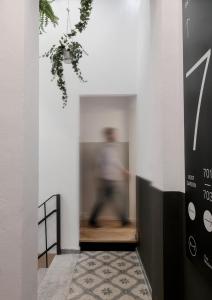 a man walking down the hallway of a house at The Modernist Thessaloniki in Thessaloniki