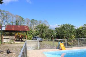 een zwembad met een glijbaan en een speeltuin bij Rancho Los Duendes in Turrialba