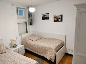 Rianjo的住宿－Trisquel Rianxo，一间小卧室,配有两张床和窗户