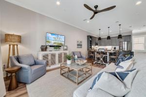 a living room with a couch and chairs and a kitchen at Newly Built, Luxury Home w/ pool & beach access in Gulf Shores