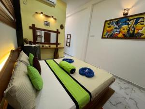 um quarto com uma cama com almofadas verdes em Thara Cabana em Bentota