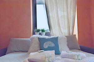 um quarto com um sofá com toalhas e uma janela em Aprica Alpine Loft Centralità e Park Free em Aprica