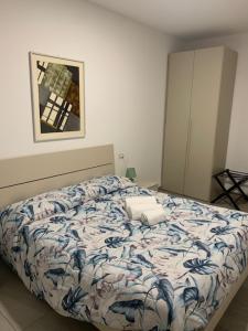 a bedroom with a bed with a blue and white comforter at Gilda e Vesuvio in Bergamo