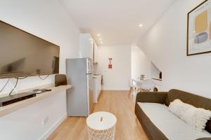 a living room with a couch and a refrigerator at By the Palace - Ajuda Apartments in Lisbon