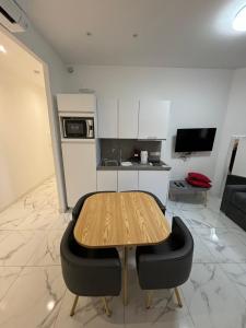 cocina con mesa de madera y 2 sillas negras en Appartement 4 couchages Idéalement placé promenade des anglais / Cours Saleya, en Niza
