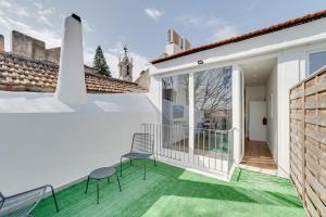 a balcony with two chairs and green grass at By the Palace - Ajuda Apartments in Lisbon