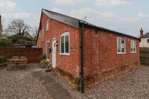 a red brick building with a pitched roof at 1 The Old Coach House in Laxfield