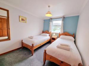 a twin bedroom with two beds and a window at Tregurrian Villas in Newquay
