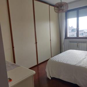 sypialnia z białym łóżkiem i oknem w obiekcie Appartamento In residence w mieście Perugia