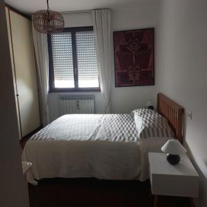 a bedroom with a white bed and a window at Appartamento In residence in Perugia