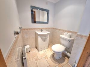 a bathroom with a toilet and a sink at Tregurrian Villas in Newquay