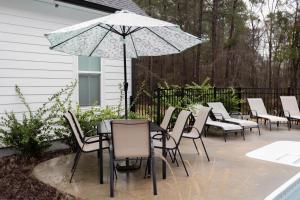 eine Terrasse mit einem Tisch, Stühlen und einem Sonnenschirm in der Unterkunft Spacious Appling Retreat in Appling