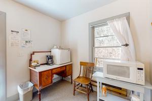 Habitación con escritorio, microondas y ventana. en Cottage 9 - The Eagle's Nest en Coupeville