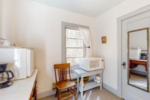 uma cozinha com um micro-ondas e uma mesa com uma cadeira em Cottage 9 - The Eagle's Nest em Coupeville