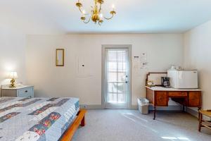 a bedroom with a bed and a desk with a microwave at Cottage 9 - The Eagle's Nest in Coupeville