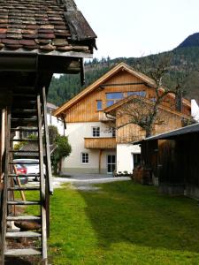 une maison avec un toit en bois dans une cour dans l'établissement Bio Ferienwohnungen im Lieblingsort 1868, à Garmisch-Partenkirchen