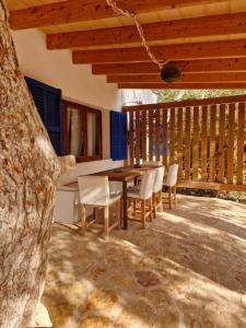 a wooden table and chairs on a patio at Casa Migjorn, immersa nella natura a pochi passi dal mare in Es Calo