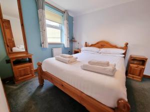 a bedroom with a bed with two towels on it at Tregurrian Villas in Newquay