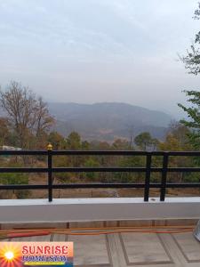 a bench with a view of the mountains at Sunrise Home Stay in Almora