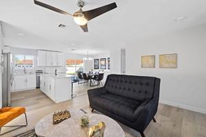 Una sala de estar con un sofá negro y una cocina. en 1 Story, 3 BR Home w Hot tub, Pool Grill, Firepit, en Las Vegas
