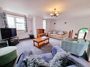 sala de estar con 2 sofás y TV en Tregurrian Villas, en Newquay