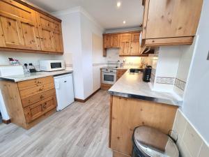 a kitchen with wooden cabinets and a counter top at Tregurrian Villas in Newquay
