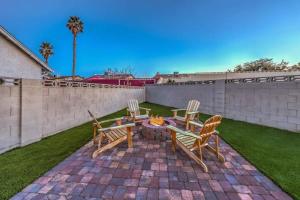 un patio con sillas, mesa y fogata en 1 Story, 3 BR Home w Hot tub, Pool Grill, Firepit, en Las Vegas