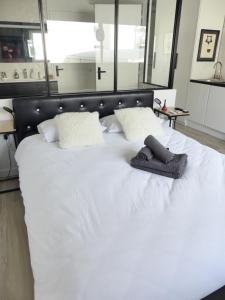 a white bed with a pair of slippers on it at La Cité des Coeurs LU Parking inclus in Nantes