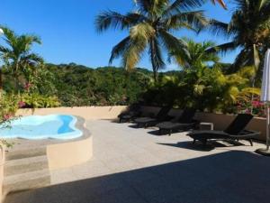 - une rangée de chaises et une piscine sur une plage dans l'établissement Pacific Inn hotel, à Sayulita