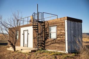 a small house with a staircase on the side of it at New Moonlight Ridge-Shipping Container Home in Alpine