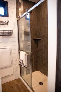 a shower with a glass door in a bathroom at New Moonlight Ridge-Shipping Container Home in Alpine